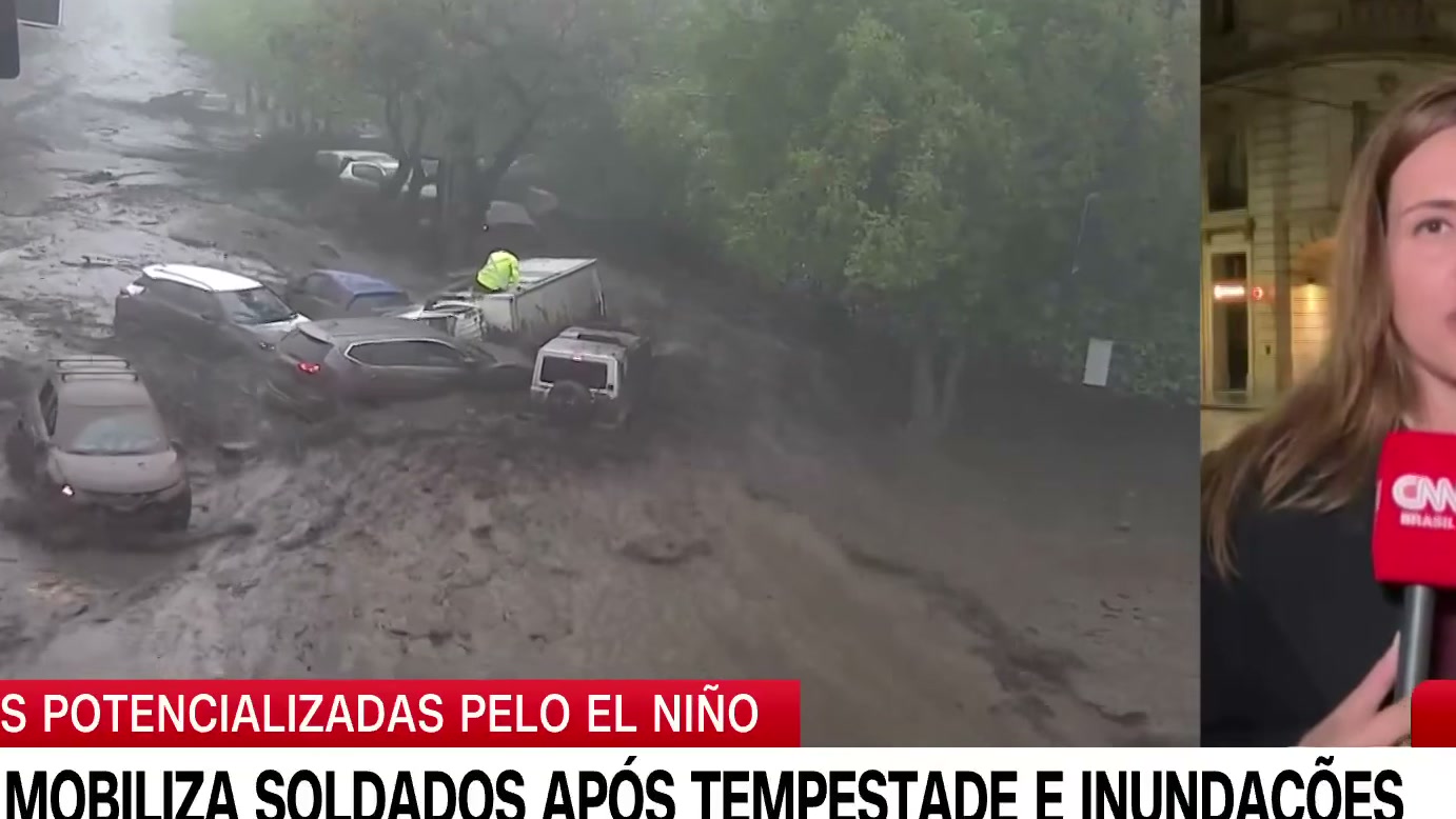 Enxurrada de lama arrasta veículos e invade casas em Santiago, mas homem consegue se salvar agarrado a uma árvore, segundo reportagem da CNN